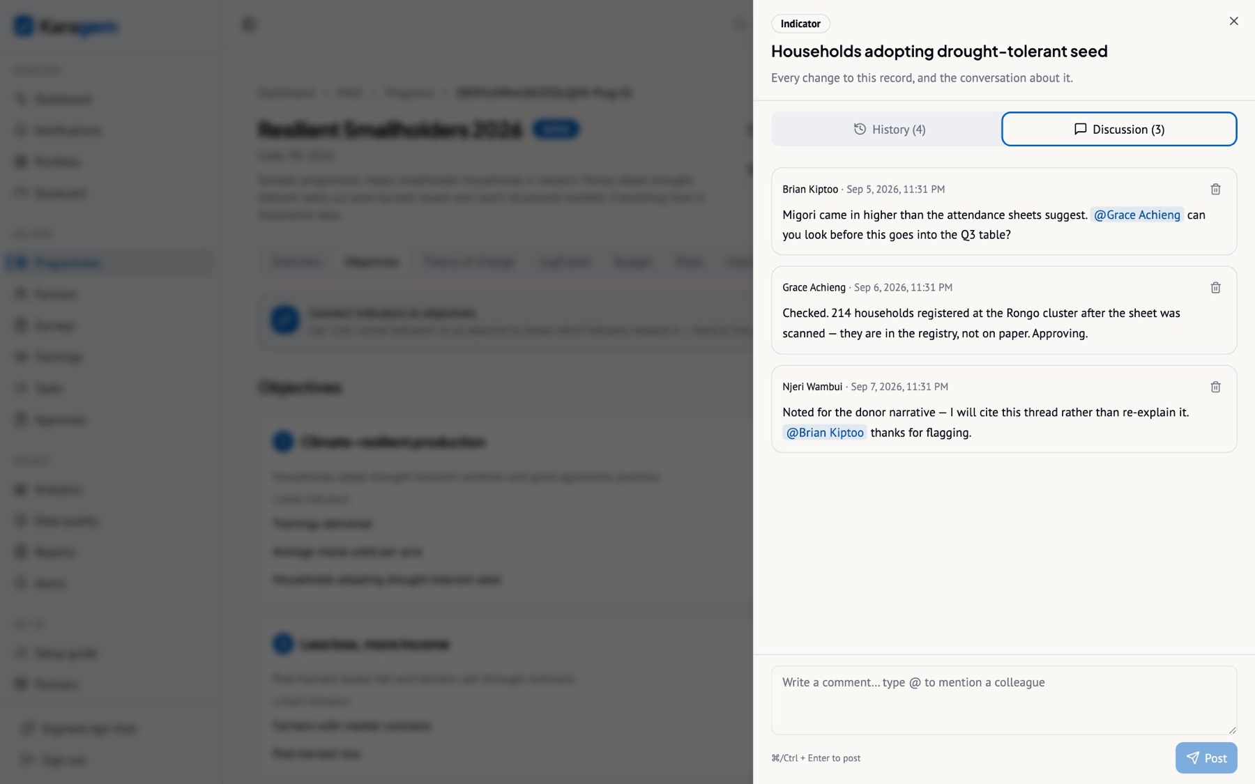 The Discussion tab of the same drawer on the sample programme’s headline indicator: an @mention, the reply that resolved it, and the note the reporting officer left for the narrative.